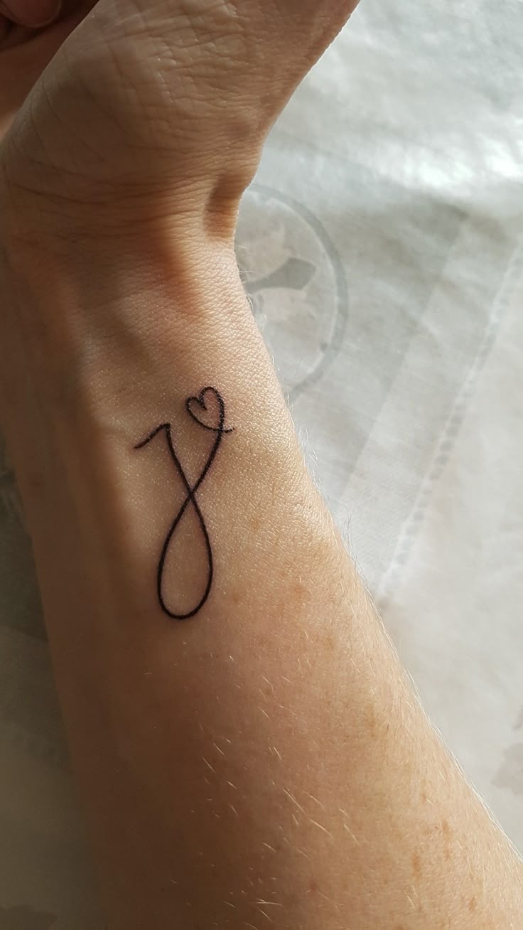 Fine line initial with heart tattoo design for women on wrist tattoo ideas
