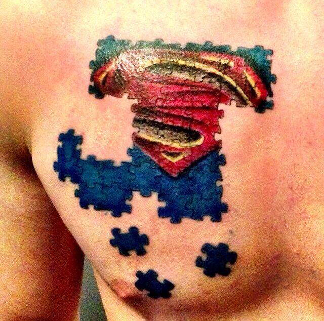 Realistic autism puzzle piece Superman logo tattoo design for men on chest tattoo ideas