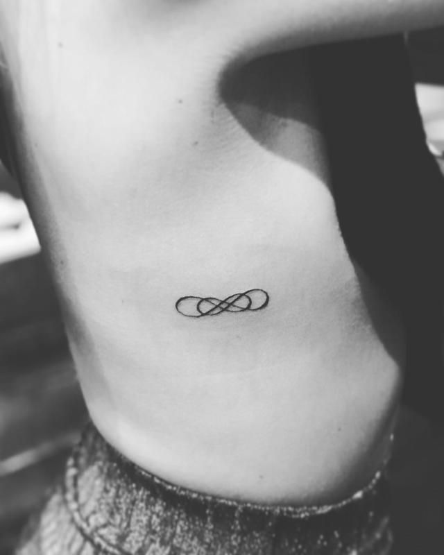 Fine line infinity symbol tattoo design for women on rib tattoo ideas