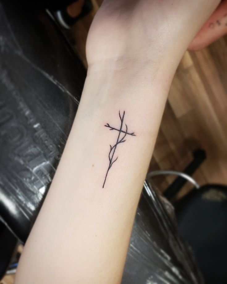 Fine line cross with branch tattoo design for women on wrist tattoo ideas