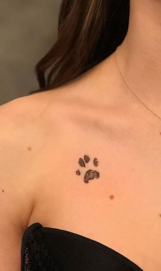 Black and grey paw print tattoo design for women on chest tattoo ideas