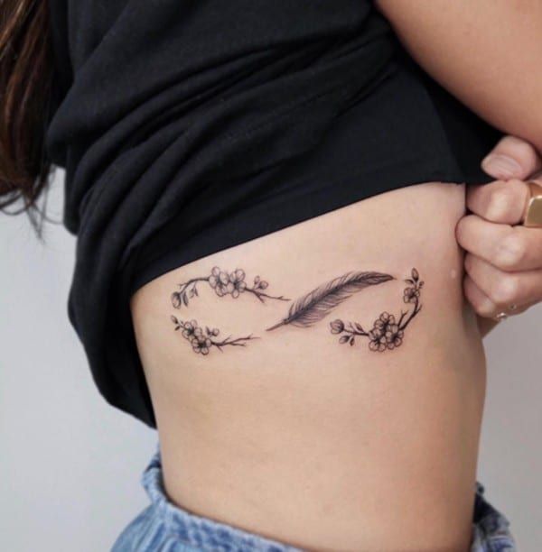 Fine line infinity feather floral tattoo design for women on rib tattoo ideas