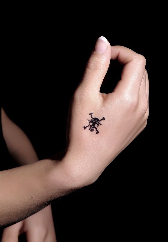 Blackwork skull and one piece tattoo design for women on hand tattoo ideas