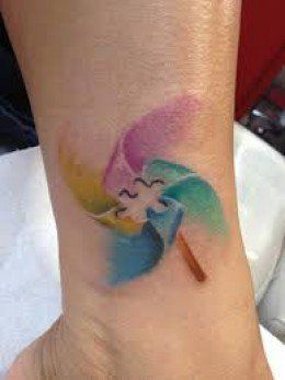 Watercolor pinwheel autism tattoo design for women on ankle tattoo ideas
