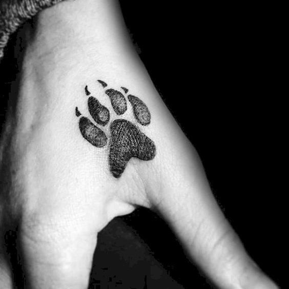 Blackwork paw print tattoo design for women on hand tattoo ideas