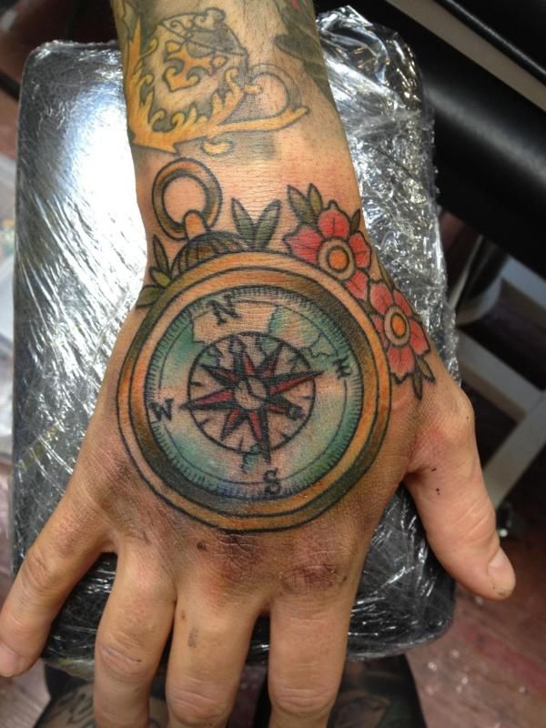 Traditional compass and floral tattoo design for men on hand tattoo ideas