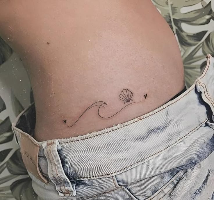 Minimalist ocean wave and seashell tattoo design for women on hip tattoo ideas