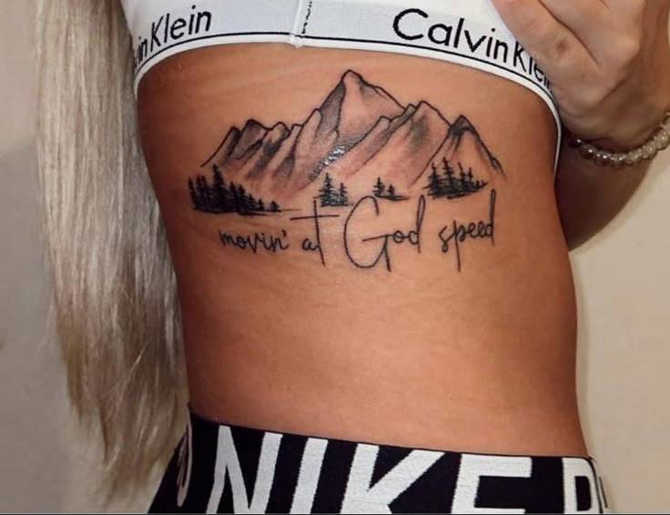 Fine line mountains, cross, and quote tattoo design for women on rib tattoo ideas