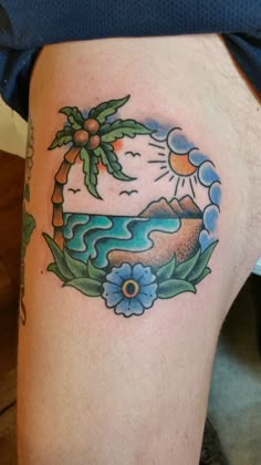 Traditional palm tree and flower tattoo design for men on thigh, featuring a sun and ocean scene tattoo ideas