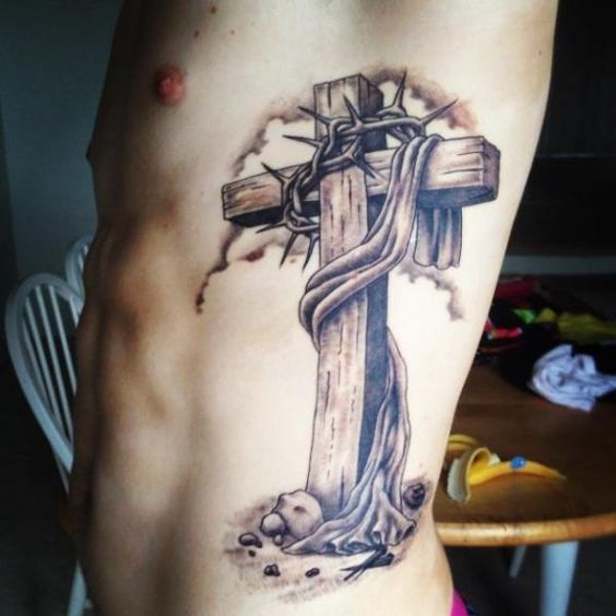 Realistic cross with crown of thorns tattoo design for men on rib tattoo ideas