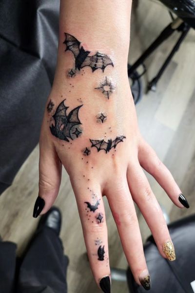 Blackwork bat and star tattoo design for women on hand and finger tattoo ideas