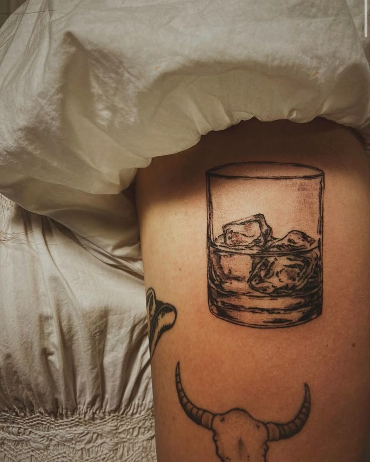 Realistic bourbon glass tattoo design for men on thigh tattoo ideas