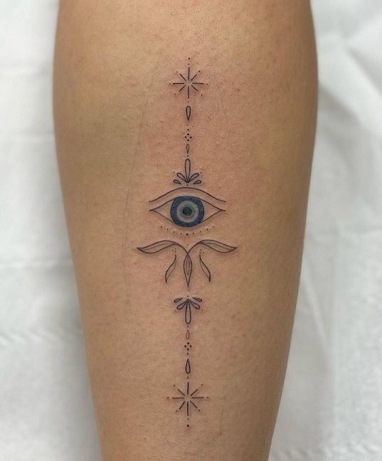 Fine Line eye, star, and floral amulet tattoo design for women on arm tattoo ideas