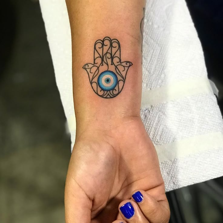 Fine line evil eye tattoo design for women on wrist tattoo ideas